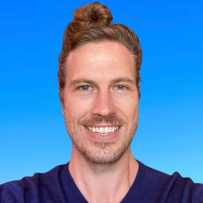 Headshot of Eric Jakobsen in front of a blue background.